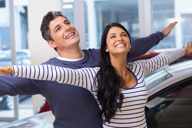 Heureux couple debout avec les bras tendus