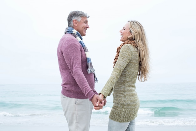 Heureux couple debout, tenant les mains des autres