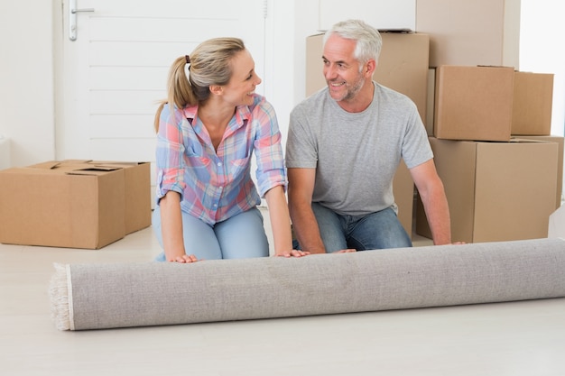 Heureux couple déployant un nouveau tapis