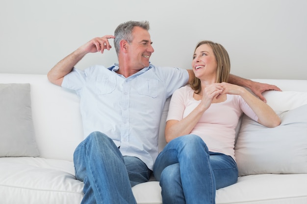 Heureux couple détendu assis sur un canapé dans le salon