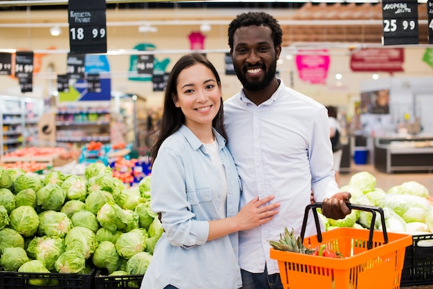 Heureux couple diversifié en épicerie