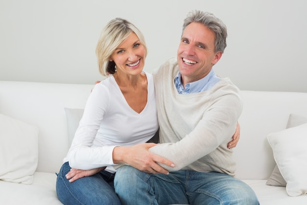 Heureux couple embrassant sur le canapé dans le salon