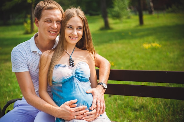 Heureux Couple enceinte dans le parc de l'été