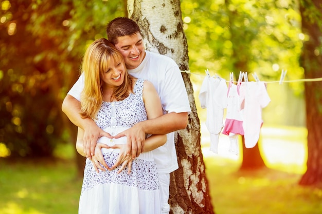 Heureux couple enceinte en forme de coeur