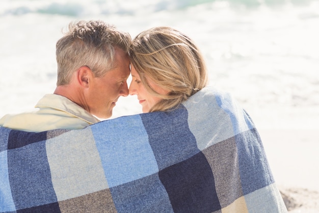 Heureux couple enveloppé dans une couverture