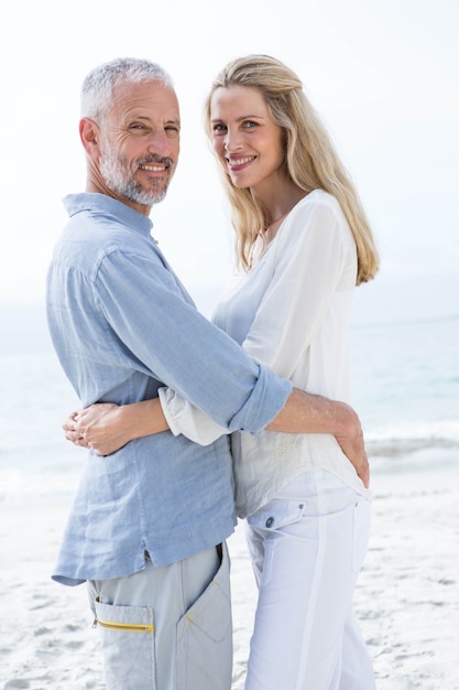 Heureux couple étreignant les uns les autres et regardant la caméra