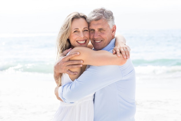 Heureux couple étreignant les uns les autres et regardant la caméra