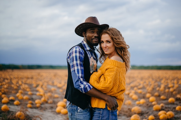 Heureux couple étreignant dans le champ de citrouilles