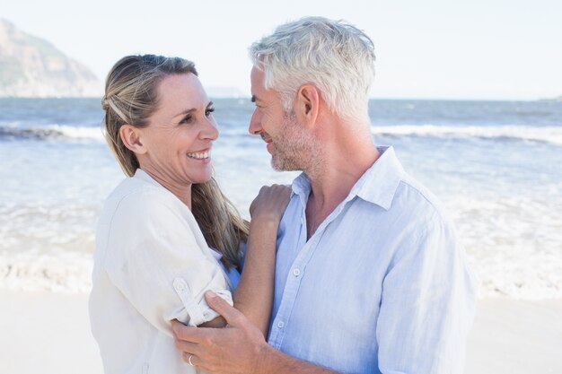 Heureux couple étreindre sur la plage en se regardant