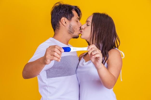 Heureux couple excité prenant un test de grossesse positif et célébrant