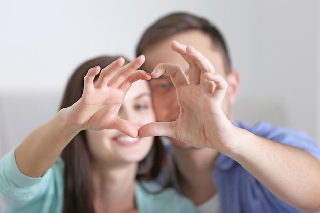 Heureux couple faisant le cœur à la main