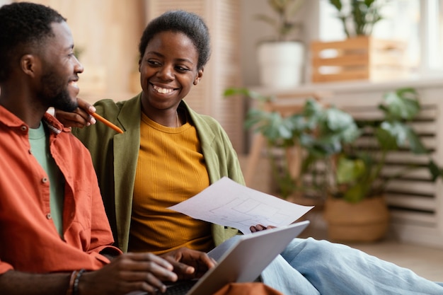 Heureux couple faisant des plans ensemble pour rénover la maison