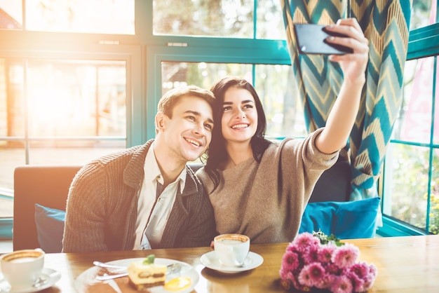 L'heureux couple faisant un selfie dans un restaurant