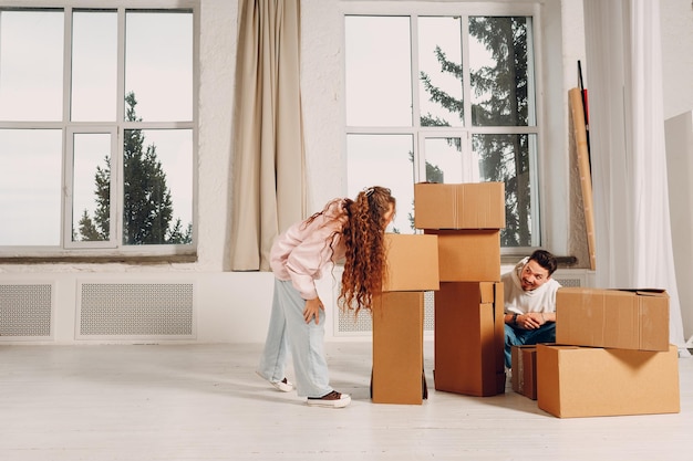 Heureux couple familial homme et femme déménageant avec des boîtes en carton vers une nouvelle maison
