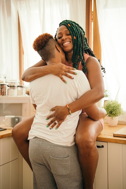 Photo heureux couple gay s'embrassant dans la cuisine