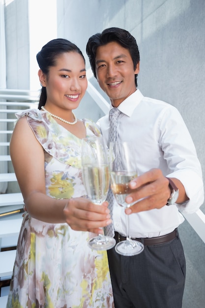 Heureux couple habillé pour une date ayant du champagne