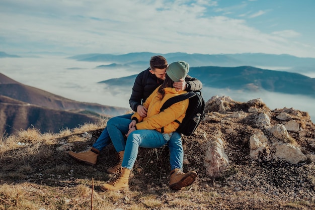 Heureux couple homme et femme touriste au sommet de la montagne lors d'une randonnée en été