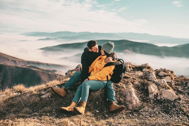 Heureux couple homme et femme touriste au sommet de la montagne lors d'une randonnée en été