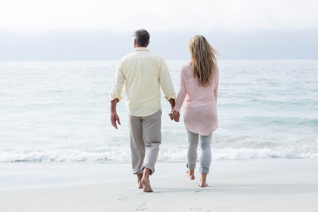 Heureux couple marchant au bord de la mer