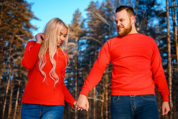 Heureux couple marchant dans la forêt enneigée