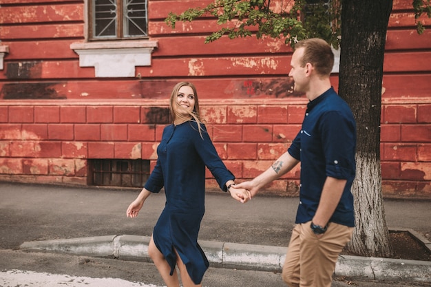 Heureux couple marchant sur le passage pour piétons dans la ville