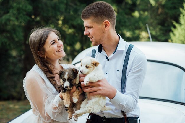 Heureux couple marié jouant avec de petits chiots.