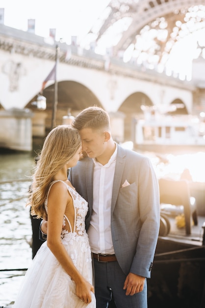 Heureux couple marié romantique étreignant près de la tour Eiffel à Paris