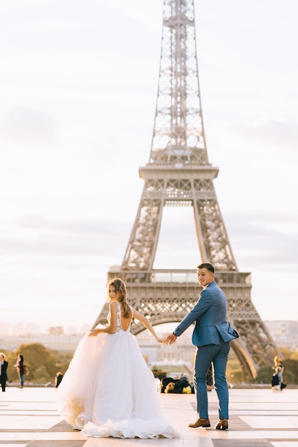 Heureux couple marié romantique étreignant près de la tour Eiffel à Paris