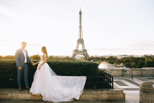 Heureux couple marié romantique étreignant près de la tour Eiffel à Paris