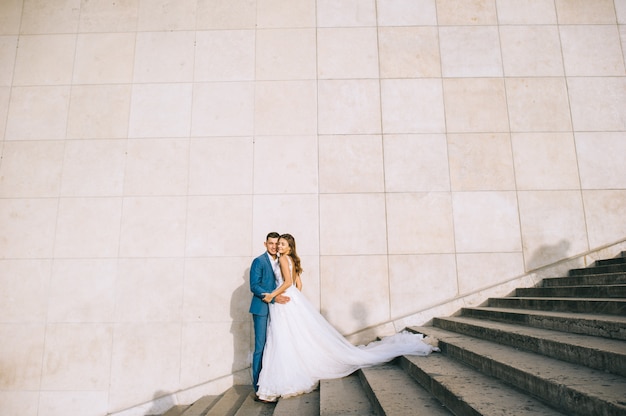 Heureux couple marié romantique, étreindre dans les escaliers