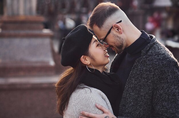 Heureux couple multiracial ensemble à l'extérieur de la ville. Fille asiatique avec son petit ami caucasien.