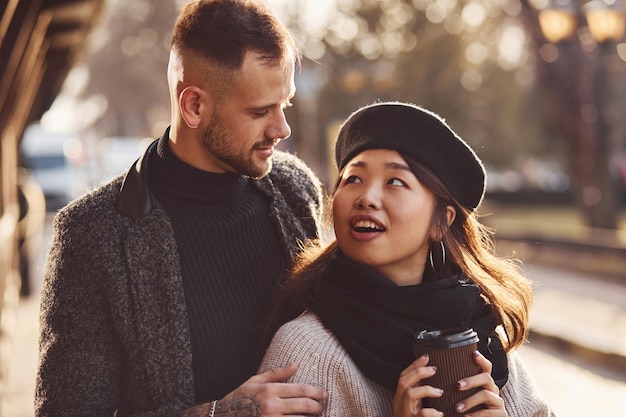 Heureux couple multiracial ensemble à l'extérieur de la ville. Fille asiatique avec son petit ami caucasien.