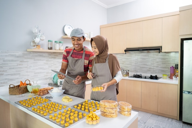 Heureux couple musulman avec tablet pc cuire un gâteau