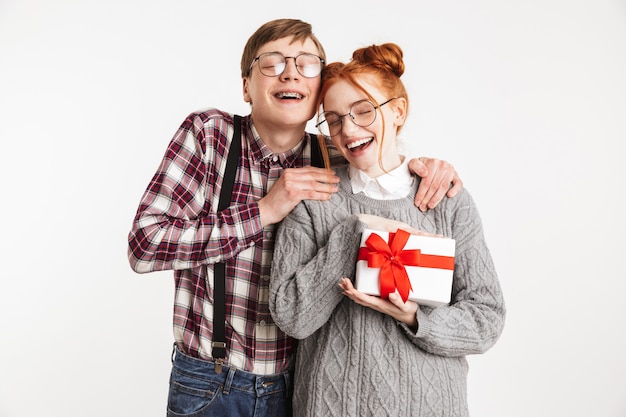 Heureux couple de nerds de l'école donnant la boîte cadeau