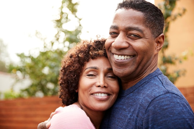 Heureux couple noir d'âge moyen embrassant le sourire à la caméra en gros plan