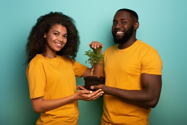 Heureux couple noir protéger un petit arbre