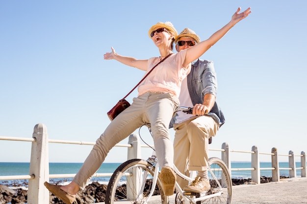 Heureux couple occasionnel pour une balade à vélo sur la jetée