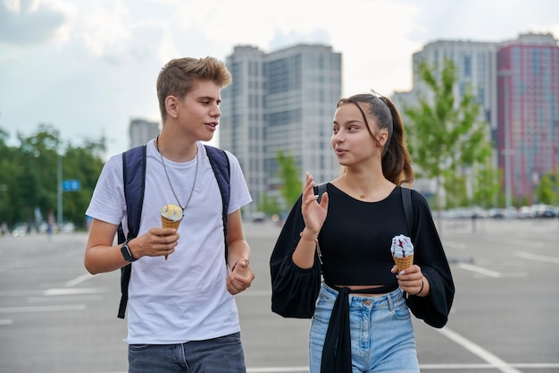 Heureux couple parlant d'adolescents marchant ensemble dans la ville