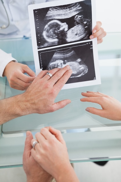 Heureux couple parlant au médecin