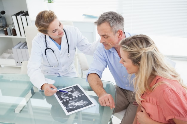 Heureux couple parlant au médecin