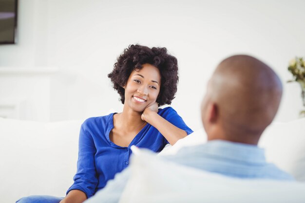 Heureux couple parlant sur le canapé à la maison