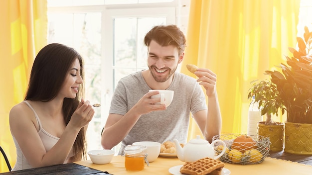 Heureux couple passer la matinée ensemble. Homme et femme décontractés amoureux prenant le petit déjeuner, espace de copie