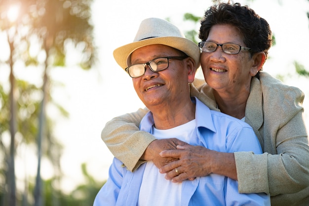 Un heureux couple de personnes âgées asiatique vieil homme et femme souriant et riant dans le jardin