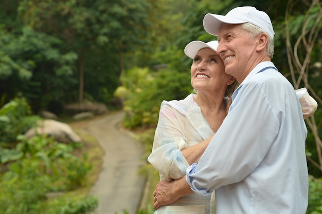 Heureux couple de personnes âgées dans un jardin tropical en plein air