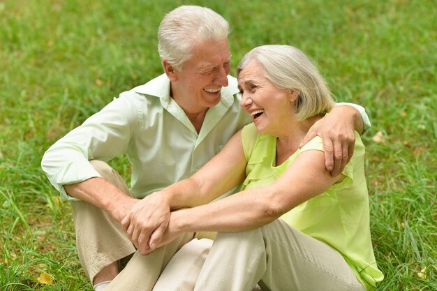 Heureux couple de personnes âgées dans le parc assis ensemble