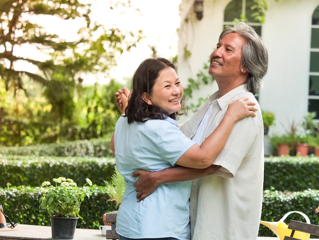 Heureux couple de personnes âgées dansent ensemble dans la maison de jardin.