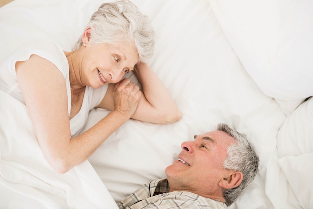 Heureux couple de personnes âgées sur le lit