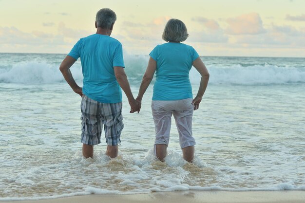 Heureux couple de personnes âgées reposant sur une plage tropicale