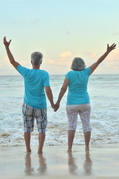 Heureux couple de personnes âgées reposant sur une plage tropicale