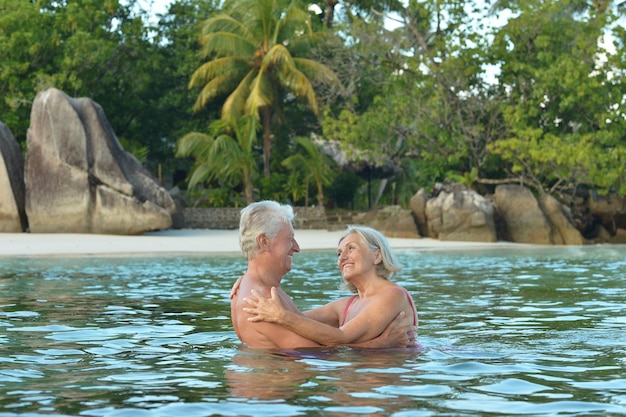 Heureux couple de personnes âgées reste à la plage tropicale